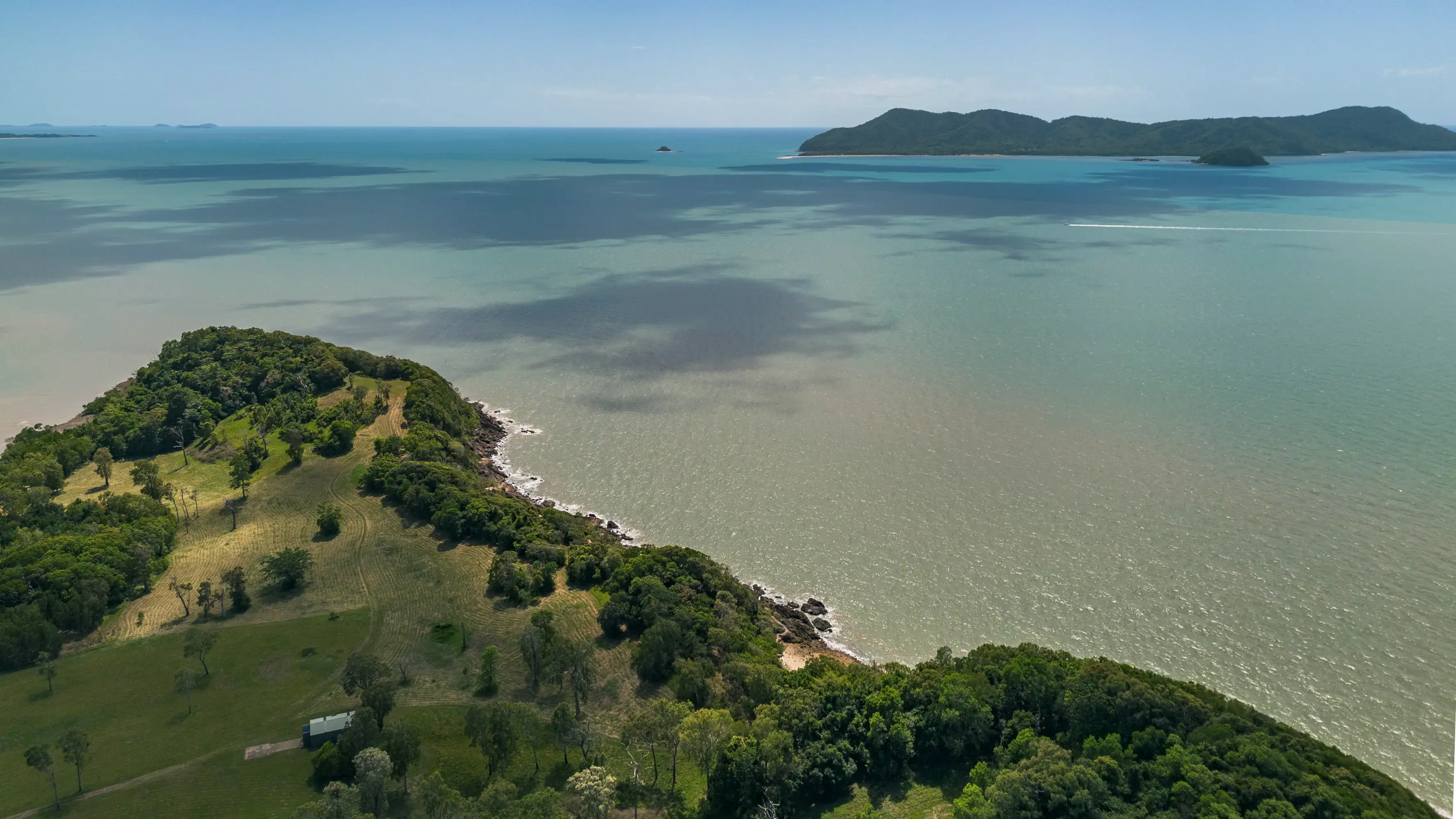 The rocky shore of the headland, an island beyond